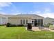 Large backyard featuring brick patio, grill, and enclosed sunroom with lots of greenery at 2066 Vermount Way, Indian Land, SC 29707