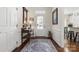 Inviting entryway featuring hardwood floors, white wainscoting, a decorative rug, and a view of the kitchen at 2066 Vermount Way, Indian Land, SC 29707