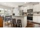 Bright kitchen with stainless steel appliances, granite counters, an island with seating, and wood floors at 2066 Vermount Way, Indian Land, SC 29707