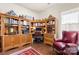 Home office with built-in bookshelves, wooden desk and floors, and accent chair at 2066 Vermount Way, Indian Land, SC 29707