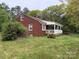 Side view of a cozy brick house featuring a white picket fence and well-maintained lawn at 2096 S Point Rd, Belmont, NC 28012