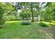 Expansive backyard with mature trees and lush lawn, featuring a trampoline for outdoor enjoyment at 257 Amity Dr, York, SC 29745