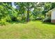 Lush backyard with mature trees and green lawn, offering a serene outdoor space with a covered patio at 257 Amity Dr, York, SC 29745