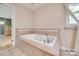 Bright bathroom featuring a tiled jacuzzi tub with chrome fixtures, providing a relaxing spa-like experience at 257 Amity Dr, York, SC 29745