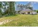 Exterior view of the back of the house featuring a well-kept lawn and tall trees in the background at 2705 Enon Church Rd, Salisbury, NC 28147