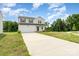 Beautiful two-story home featuring a two-car garage and a lush, partially wooded front yard at 3077 Light Ridge Sw Ct, Concord, NC 28027