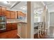 Modern kitchen with a bar, stainless steel microwave, and wooden cabinetry, seamlessly connected to other rooms at 3106 Crosswind Dr, Fort Mill, SC 29707