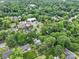 Nestled in lush greenery, the aerial view showcases homes near a charming church and community buildings at 3327 Archdale Dr, Charlotte, NC 28210