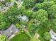 A high angle shot reveals rooftops nestled among vibrant green trees, showcasing the property's secluded location at 3327 Archdale Dr, Charlotte, NC 28210