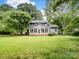 Charming home exterior with a bright sunroom, surrounded by lush green landscaping, offering serene outdoor living at 3327 Archdale Dr, Charlotte, NC 28210