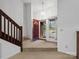 Bright foyer features a staircase, tiled floor, and a view through the glass front door to the outdoor landscape at 3327 Archdale Dr, Charlotte, NC 28210