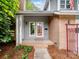 Inviting front porch with brick accents, framed by lush greenery and a well-maintained landscape, leads to the front door at 3327 Archdale Dr, Charlotte, NC 28210