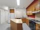 Bright kitchen with wood cabinets, an island, and modern appliances offering a functional layout at 3327 Archdale Dr, Charlotte, NC 28210
