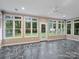 Bright sunroom with mosaic stone flooring and walls of windows overlooking backyard at 3327 Archdale Dr, Charlotte, NC 28210