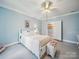 Light blue bedroom with a white bed, ceiling fan, and an open doorway to another room at 408 S Ellis St, Salisbury, NC 28144