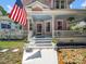 Close up of the Victorian pink home's porch, featuring an American flag and hanging flower baskets at 408 S Ellis St, Salisbury, NC 28144