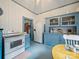Open-concept kitchen features blue cabinets, white appliances, and access to other rooms at 408 S Ellis St, Salisbury, NC 28144