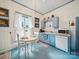 An eat-in kitchen offers blue cabinetry, white appliances, and an adjacent kitchen table at 408 S Ellis St, Salisbury, NC 28144