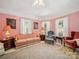 Spacious living room with vintage decor, a fireplace, and large windows, offering comfortable seating options at 408 S Ellis St, Salisbury, NC 28144