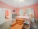 Comfortable main bedroom featuring vintage furniture, soft lighting, and a view into the en-suite bath at 408 S Ellis St, Salisbury, NC 28144