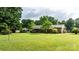 Spacious backyard with lush greenery and a charming outbuilding for storage at 518 W School St, Maiden, NC 28650