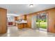 Eat-in kitchen featuring wood paneled walls and sliding glass door with view to fenced backyard at 518 W School St, Maiden, NC 28650