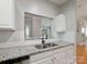 Well-lit kitchen featuring white cabinets, granite countertops, stainless steel sink, and modern fixtures at 5617 Fairview Rd # 9, Charlotte, NC 28209