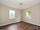 Bedroom featuring neutral walls, wood-look floors, and natural light from two windows at 6225 Macon St, Charlotte, NC 28208