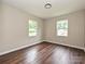Bedroom featuring wood-look floors, a closet, and natural light from two windows at 6225 Macon St, Charlotte, NC 28208