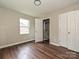 Bright bedroom featuring wood-look floors and door to a shower at 6225 Macon St, Charlotte, NC 28208