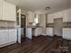 Open-concept kitchen boasts white cabinets, granite counters and sleek wood floors, newly renovated at 6225 Macon St, Charlotte, NC 28208