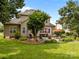 Landscaped backyard featuring a patio, garden, mature trees and a lush lawn, offering a serene outdoor space at 6533 Derby Nw Ln, Concord, NC 28027