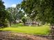 Expansive backyard with mature trees and a patio with outdoor furniture, offering a serene and private outdoor oasis at 6533 Derby Nw Ln, Concord, NC 28027