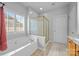 Bright bathroom with a soaking tub under a window and a separate glass shower at 6533 Derby Nw Ln, Concord, NC 28027