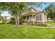 Inviting two-story home with lush green lawn, mature trees, and a charming front porch at 6533 Derby Nw Ln, Concord, NC 28027