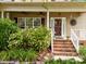 Welcoming front porch with brick steps, white railings, and views of beautiful landscaping at 6533 Derby Nw Ln, Concord, NC 28027