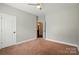 A bedroom featuring neutral walls, carpet flooring, with a view into an ensuite bath at 6618 Alexander Rd, Charlotte, NC 28270