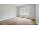 Bedroom featuring neutral walls, carpet flooring, and a well-lit window at 6618 Alexander Rd, Charlotte, NC 28270