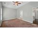 A neutral bedroom featuring a trey ceiling, carpeted floors, and an ensuite bathroom at 6618 Alexander Rd, Charlotte, NC 28270