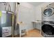 Laundry room with tile floors, a utility sink, washer/dryer, and a water heater at 6618 Alexander Rd, Charlotte, NC 28270
