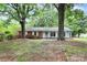 Charming single-story home featuring a mix of brick and siding with a manicured lawn and mature trees at 7118 April Ridge Ln, Charlotte, NC 28215