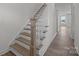 Close-up of the staircase with natural wood trim, white risers and wood-look floors at 725 Sirius Ln # 90, York, SC 29745