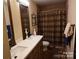 Bathroom with double sink vanity and rustic wood accents, alongside a shower with a patterned curtain at 746 Sinclair Dr, Monroe, NC 28112