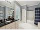 Well-lit bathroom with a marble floor, black countertop, and shower and tub combination at 828 Colville Rd, Charlotte, NC 28207