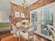 Charming dining room with a brick wall, glass table, and white chairs at 828 Colville Rd, Charlotte, NC 28207
