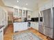 Beautiful kitchen with white cabinets, stainless steel fridge, and herringbone wood floors at 828 Colville Rd, Charlotte, NC 28207