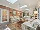 Comfortable living room featuring an area rug, a brick wall, and skylights at 828 Colville Rd, Charlotte, NC 28207
