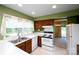 Kitchen with double sink, white appliances, wood cabinets, and view to a room beyond at 8356 Meadow Lakes Dr, Charlotte, NC 28210