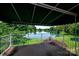 Scenic lake view from the screened porch featuring a white-railed balcony and a green awning at 8356 Meadow Lakes Dr, Charlotte, NC 28210