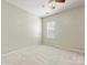 A view of a neutral-toned bedroom with plush carpet and a single window at 8603 Robinson Meadow Ct, Charlotte, NC 28277